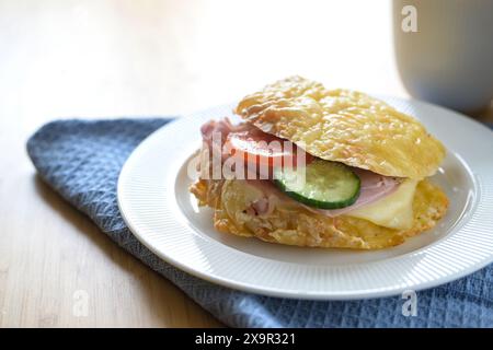 Panino al formaggio con tacchino bollito, pomodoro e cetriolo su un piatto come spuntino per il pranzo, spazio per copiare, messa a fuoco selezionata, profondità di campo ridotta Foto Stock