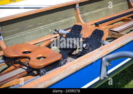 Sedile scorrevole in legno e poggiapiedi fisso in una barca a remi sportiva costruita per gare e regate, focus selezionato Foto Stock