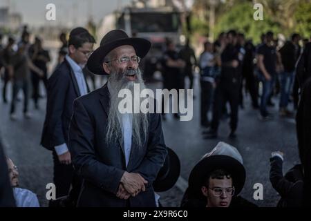 Bnei Brak, Israele. 2 giugno 2024. I manifestanti ebrei ultra-ortodossi bloccano una strada a Bnei Brak, durante una protesta contro possibili cambiamenti nelle leggi esentano gli uomini ultra-ortodossi dalla coscrizione militare. Crediti: Ilia Yefimovich/dpa/Alamy Live News Foto Stock