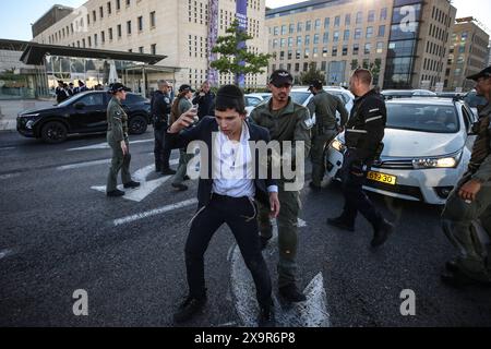 La polizia DI PROTESTA DI DIFESA ISRAELIANA MIDEAST rimuove gli ebrei ultra-ortodossi che bloccano una strada durante una protesta contro la coscrizione militare al di fuori della Corte suprema israeliana a Gerusalemme, 2 giugno 2024. La Corte Suprema d'Israele ascolta il 2 giugno una risposta dello stato sulla questione del reclutamento ultra ortodosso, dopo aver precedentemente prorogato un termine per la presentazione da parte del governo di un piano di coscrizione per gli ebrei ultra-ortodossi, che sono tradizionalmente esenti dal servizio militare. Foto di saeed qaq Copyright: XSAEEDQAQx AX4X1975 Foto Stock