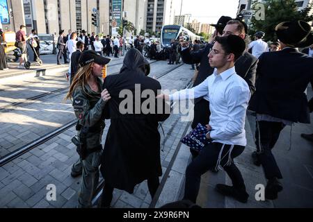 La polizia DI PROTESTA DI DIFESA ISRAELIANA MIDEAST rimuove gli ebrei ultra-ortodossi che bloccano una strada durante una protesta contro la coscrizione militare al di fuori della Corte suprema israeliana a Gerusalemme, 2 giugno 2024. La Corte Suprema d'Israele ascolta il 2 giugno una risposta dello stato sulla questione del reclutamento ultra ortodosso, dopo aver precedentemente prorogato un termine per la presentazione da parte del governo di un piano di coscrizione per gli ebrei ultra-ortodossi, che sono tradizionalmente esenti dal servizio militare. Foto di saeed qaq Copyright: XSAEEDQAQx AX4X2220 Foto Stock
