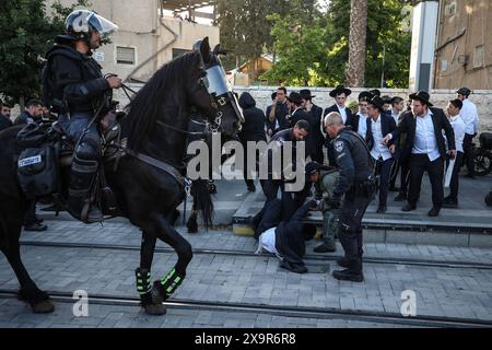 La polizia DI PROTESTA DI DIFESA ISRAELIANA MIDEAST rimuove gli ebrei ultra-ortodossi che bloccano una strada durante una protesta contro la coscrizione militare al di fuori della Corte suprema israeliana a Gerusalemme, 2 giugno 2024. La Corte Suprema d'Israele ascolta il 2 giugno una risposta dello stato sulla questione del reclutamento ultra ortodosso, dopo aver precedentemente prorogato un termine per la presentazione da parte del governo di un piano di coscrizione per gli ebrei ultra-ortodossi, che sono tradizionalmente esenti dal servizio militare. Foto di saeed qaq Copyright: XSAEEDQAQx AX4X2230 Foto Stock
