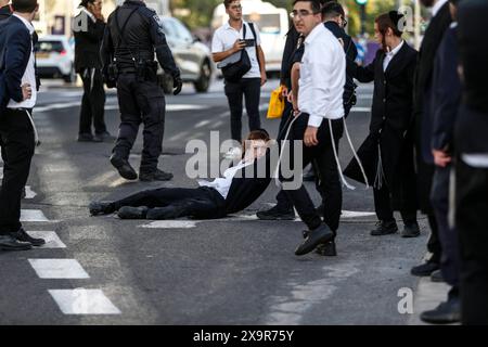 La polizia DI PROTESTA DI DIFESA ISRAELIANA MIDEAST rimuove gli ebrei ultra-ortodossi che bloccano una strada durante una protesta contro la coscrizione militare al di fuori della Corte suprema israeliana a Gerusalemme, 2 giugno 2024. La Corte Suprema d'Israele ascolta il 2 giugno una risposta dello stato sulla questione del reclutamento ultra ortodosso, dopo aver precedentemente prorogato un termine per la presentazione da parte del governo di un piano di coscrizione per gli ebrei ultra-ortodossi, che sono tradizionalmente esenti dal servizio militare. Foto di saeed qaq Copyright: XSAEEDQAQx  B9Z4159 Foto Stock