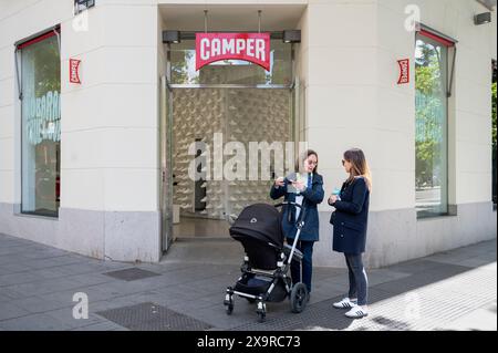 Le donne si vedono al di fuori del negozio camper, marchio multinazionale spagnolo di produzione e vendita al dettaglio di calzature, in Spagna. Foto Stock