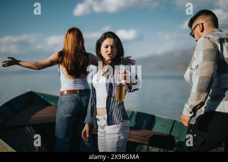 Giovani amici che condividono le risate in una giornata di sole in riva al lago, catturando momenti di divertimento e divertimento all'aria aperta Foto Stock