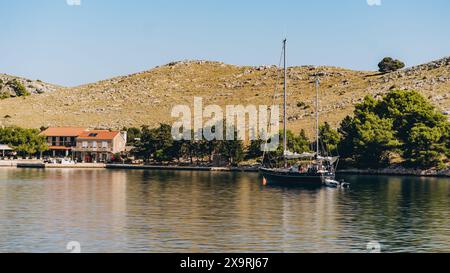 Vecchia nave con vele e scialuppa di salvataggio che galleggia al largo della costa dell'isola di Dugi Otok nel Mare Adriatico, Croazia Foto Stock