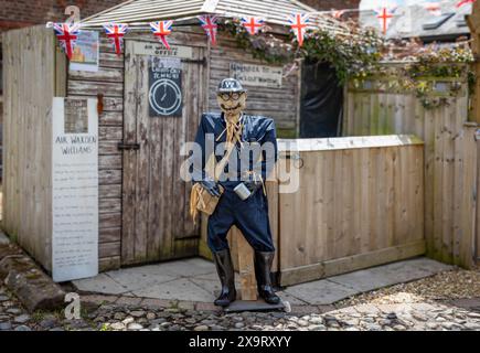 Daresbury Village, Cheshire, Regno Unito. 2 giugno 2024. Alcune persone non sono state in grado di unirsi e combattere in guerra, come il signor Williams, miope. Hanno aiutato creando il fronte interno. Qui Air Warden Williams è rappresentato da uno spaventapasseri nel Daresbury Village Scarecrow Festival per commemorare il 80° anniversario del D-Day Credit: John Hopkins/Alamy Live News Foto Stock