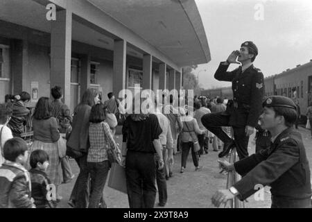 Passeggeri diretti a un treno diesel diretto a sud, alla stazione ferroviaria lo Wu, alla ferrovia Kowloon-Canton, Hong Kong, Capodanno lunare 1981. La folla in attesa è appena tornata a Hong Kong dalla Cina continentale. I poliziotti sulla piattaforma sono impegnati nella gestione della folla, a causa dell'elevato numero di passeggeri durante le festività. Foto Stock