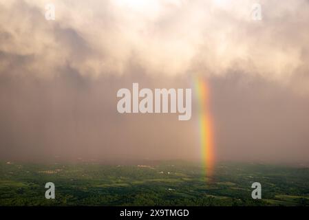 Un arcobaleno è visibile dalla cima della montagna Sharp Top al tramonto nelle Blue Ridge Mountains della Virginia Foto Stock