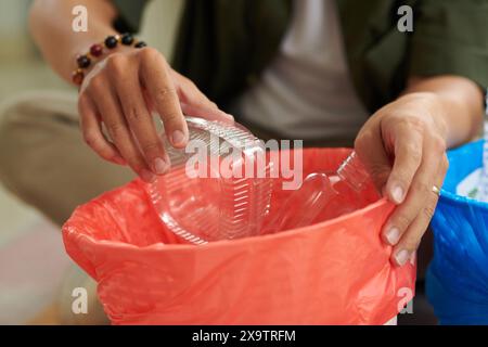 Immagine ravvicinata di un uomo che smistava la spazzatura in cesti diversi Foto Stock