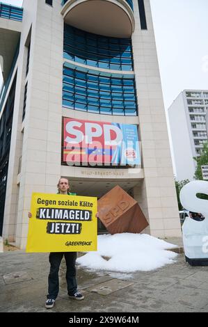 Greenpaece-aktive protestierten am Montag 03.06.2024 mit einem gefrorenem S und einer 1 tonne Eis vor der SPD-Zentrale in der Wilhelmstrasse a Berlino fuer ein schnelles Klimageld. Ohne die Einfuehrung des Klimageldes drohen vor allem Haushalten mit niedrigem und mittlerem Einkommen hohe Belastungen aufgrund von CO2-Kosten. Laut der Studie Klimageld schafft Ausgleich - Effekte von CO2-Preisen und Entlastungswirkung eines umfassenden Klimagelds , Die UmweltOrganization Greenpeace am Montag veroeffentlichte, entstehen Haushalten mit mittleren Einkommen im kommenden Jahr Mehrbelastungen von d Foto Stock