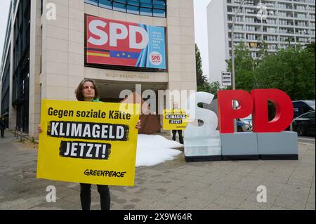 Greenpaece-aktive protestierten am Montag 03.06.2024 mit einem gefrorenem S und einer 1 tonne Eis vor der SPD-Zentrale in der Wilhelmstrasse a Berlino fuer ein schnelles Klimageld. Ohne die Einfuehrung des Klimageldes drohen vor allem Haushalten mit niedrigem und mittlerem Einkommen hohe Belastungen aufgrund von CO2-Kosten. Laut der Studie Klimageld schafft Ausgleich - Effekte von CO2-Preisen und Entlastungswirkung eines umfassenden Klimagelds , Die UmweltOrganization Greenpeace am Montag veroeffentlichte, entstehen Haushalten mit mittleren Einkommen im kommenden Jahr Mehrbelastungen von d Foto Stock