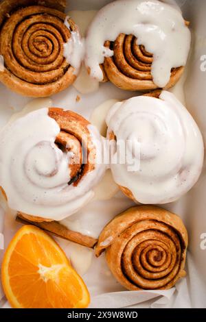 Panini alla cannella appena sfornati. Panini alla cannella fatti in casa con glassa. Pasticceria di Natale Foto Stock