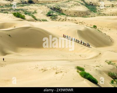 Ordos, Cina. 3 giugno 2024. Il 31 maggio 2024 i turisti cavalcano cammelli nel punto panoramico di Yinkantara nel deserto di Kubuqi a Ordos, regione autonoma della Mongolia interna, Cina. (Foto di Costfoto/NurPhoto) credito: NurPhoto SRL/Alamy Live News Foto Stock