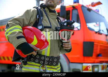 Vigile del fuoco in uniforme con casco e maschera all'aperto, messa a fuoco selettiva Foto Stock