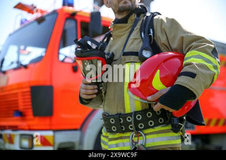 Vigile del fuoco in uniforme con casco e maschera all'aperto, messa a fuoco selettiva Foto Stock