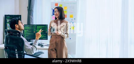 Due sviluppatori di software partecipano a una discussione durante la pausa caffè in un ufficio moderno, rilassano le emozioni Foto Stock