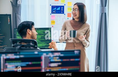 Due sviluppatori di software partecipano a una discussione durante la pausa caffè in un ufficio moderno, rilassano le emozioni Foto Stock