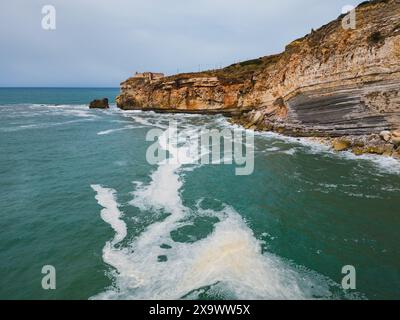 Farol da Nazare in Portogallo, paesaggio vicino all'oceano in una giornata primaverile, vista aerea dei droni. Foto Stock