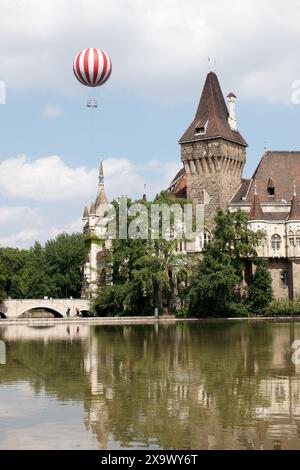 La vista del castello di Vajdahunyad nel parco della città di Budapest (Városliget). La mongolfiera che sale fino a 150 metri è visibile anche nell'immagine. Foto Stock