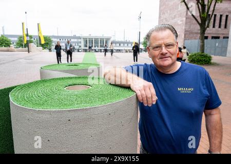 Dortmund, Germania. 3 giugno 2024. Calcio: Prima dei Campionati europei, Manfred Schepp, proprietario della società di costruzioni Bellluci, si erge sulla prima sezione di tappeto per UEFA EURO 2024. Durante i Campionati europei, un tappeto correrà attraverso il centro della città. Il percorso artificiale per il tappeto erboso inizia al Katharinentreppe presso la stazione ferroviaria principale e termina poco prima dello stadio. Il percorso verde ha lo scopo di guidare i visitatori al torneo, mostrarli in giro per la città e alleviare la congestione del traffico. Credito: David Inderlied/dpa/Alamy Live News Foto Stock