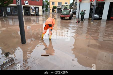 Rudersberg, Germania. 3 giugno 2024. Un operaio lavora su una strada fangosa dopo una tempesta. Per giorni, gli aiutanti in Baviera e nel Baden-Württemberg hanno combattuto l'alluvione e le sue conseguenze. La situazione delle inondazioni rimane dinamica e confusa. Molte piccole comunità sono colpite e in alcuni luoghi la situazione sta peggiorando. Crediti: Bernd Weißbrod/dpa/Alamy Live News Foto Stock