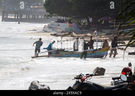 Krui West Coast, Lampung; 28 maggio 2024; i pescatori si rifugiarono per spingere le loro piccole barche da pesca fino a quando non si riposarono sul bordo del porto di Jukung, Krui Foto Stock