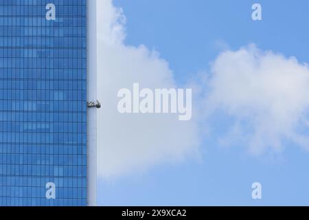 Immagine di lavoratori che dipingono un grattacielo su un'impalcatura Foto Stock