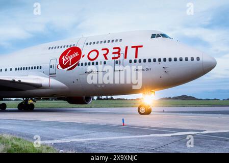 Una vista ravvicinata del logo dell'azienda e della livrea sull'aereo della Virgin Orbit Cosmic Girl, un 747-400 convertito in una piattaforma di lancio di razzi che rullava fino ad un arresto sulla pista dello Spaceport Cornwall a Newquay in Cornovaglia. Foto Stock