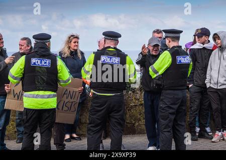 Agenti di polizia di Devon e Cornovaglia che parlano con persone che protestano contro i richiedenti asilo alloggiati nel Beresford Hotel di Newquay, in Cornovaglia, nel Regno Unito. Foto Stock