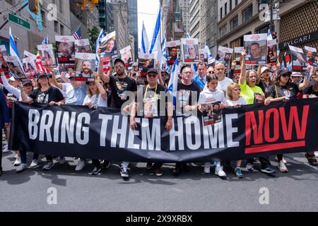 New York, Stati Uniti. 2 giugno 2024. Le famiglie degli ostaggi presi il 7 ottobre guidano la sfilata tenendo uno striscione "Bring Them Home Now" e poster dei loro cari. La 59a parata annuale dell'Israel Day marcia sulla 5a Avenue lungo Central Park. La sfilata celebra la cultura e l'orgoglio israeliani. La parata ha assunto un tono cupo quest'anno nel mezzo della guerra Israele-Hamas, con l'obiettivo principale di portare a casa i restanti 120 ostaggi ancora a Gaza che sono stati rapiti il 7 ottobre 2023. Credito: SOPA Images Limited/Alamy Live News Foto Stock