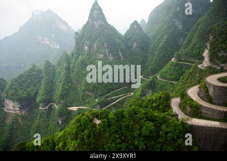 Ammira la catena montuosa paesaggistica e la curva della strada 99 per i cinesi i viaggiatori stranieri visitano la grotta di Tianmen o la porta del cielo sul monte Tianmen Foto Stock