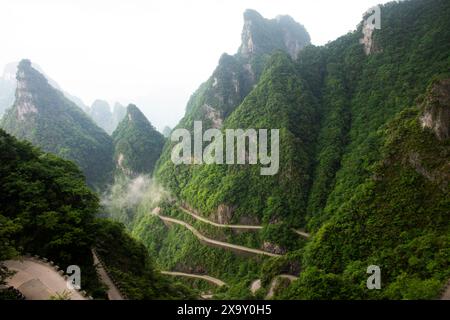 Ammira la catena montuosa paesaggistica e la curva della strada 99 per i cinesi i viaggiatori viaggiano visitando la grotta Tianmen Shan Heaven Gate nel monte Tianmenshan N. Foto Stock