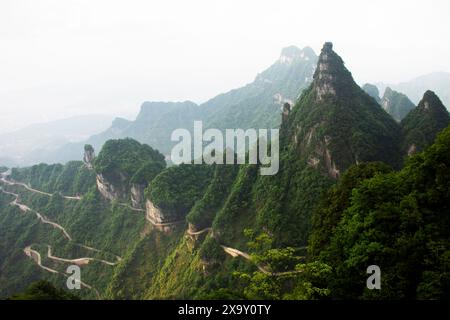 Ammira la catena montuosa paesaggistica e la curva della strada 99 per i cinesi i viaggiatori viaggiano visitando la grotta Tianmen Shan Heaven Gate nel monte Tianmenshan N. Foto Stock