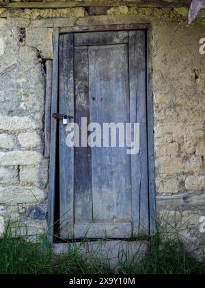 La porta di legno intemprata di un antico capannone in adobe, in una fattoria sulle montagne andine orientali della Colombia centrale. Foto Stock