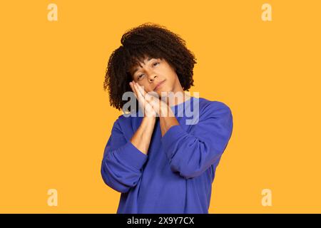 Giovane uomo con maglione blu che finge di dormire Foto Stock
