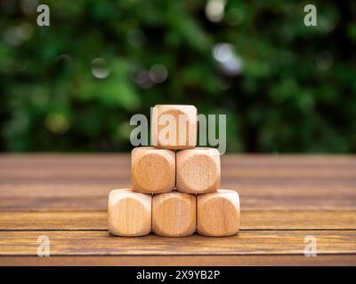 Triangolo di successo, processo di crescita aziendale, organizzazione sostenibile e concetto di istruzione. I blocchi vuoti di cubo in legno creano una forma piramidale Foto Stock