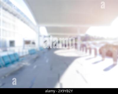 Cortile con passerella vuoto e sfocato nel moderno edificio interno del terminal dell'aeroporto. Area di prelievo e rientro dei passeggeri sfocata all'esterno del terminal dell'aeroporto Foto Stock