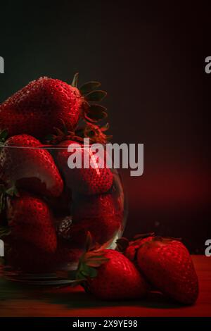 Primo piano di fragole fresche in una ciotola su un tavolo di legno Foto Stock
