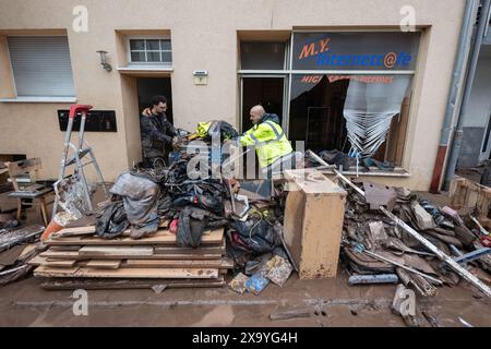 Rudersberg, Germania. 3 giugno 2024. La gente pulisce di fronte a un Internet café danneggiato. Crediti: Marijan Murat/dpa/Alamy Live News Foto Stock