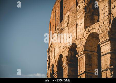 Un dettagliato primo piano del Colosseo romano sotto un cielo blu Foto Stock