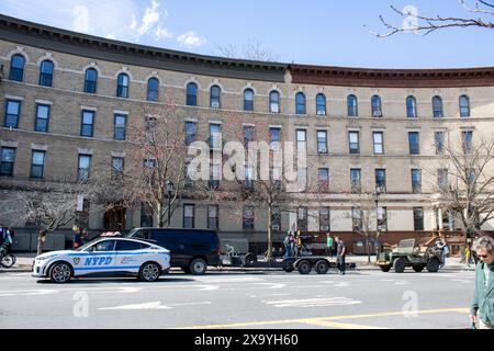 Una scena urbana con un'auto della polizia che passa davanti a un edificio cittadino di New York Foto Stock