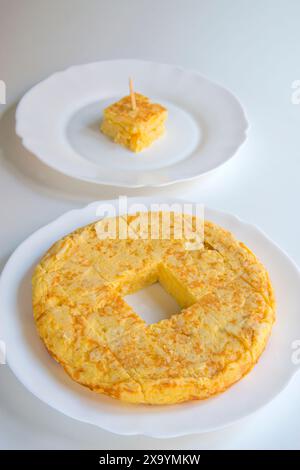 Frittata spagnola tagliato a pezzi in un piatto e un pezzo di esso in un altro piatto. Foto Stock