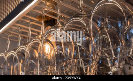 I bicchieri da vino capovolti illuminati da una lampadina in un bar Zafra, in Spagna Foto Stock