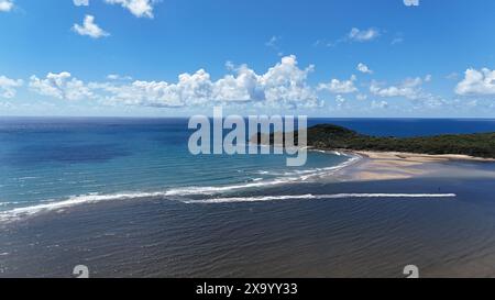 Una spiaggia sabbiosa con dolci onde che si infrangono sulla riva Foto Stock