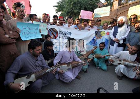 I membri della società civile stanno organizzando proteste musicali contro la violenza strutturale, al club stampa di Peshawar lunedì 3 giugno 2024. Foto Stock