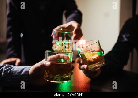 Un gruppo di uomini d'affari ha tenuto insieme gli occhiali di brandy per applaudire gli occhiali di brandy dopo aver concluso le trattative sulle imprese e aver raggiunto un sati Foto Stock
