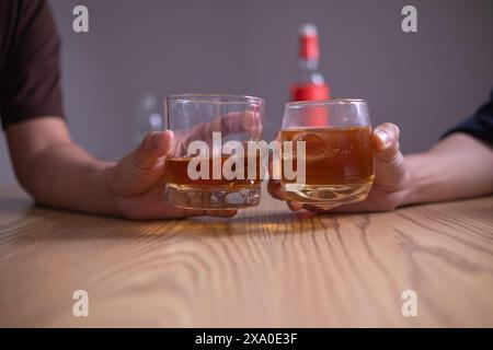 Un gruppo di uomini d'affari ha tenuto insieme gli occhiali di brandy per applaudire gli occhiali di brandy dopo aver concluso le trattative sulle imprese e aver raggiunto un sati Foto Stock