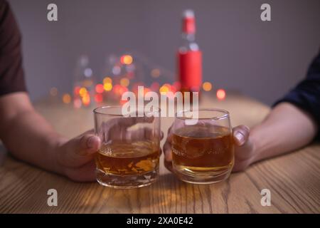 Un gruppo di uomini d'affari ha tenuto insieme gli occhiali di brandy per applaudire gli occhiali di brandy dopo aver concluso le trattative sulle imprese e aver raggiunto un sati Foto Stock
