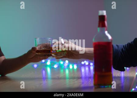 Un gruppo di uomini d'affari ha tenuto insieme gli occhiali di brandy per applaudire gli occhiali di brandy dopo aver concluso le trattative sulle imprese e aver raggiunto un sati Foto Stock